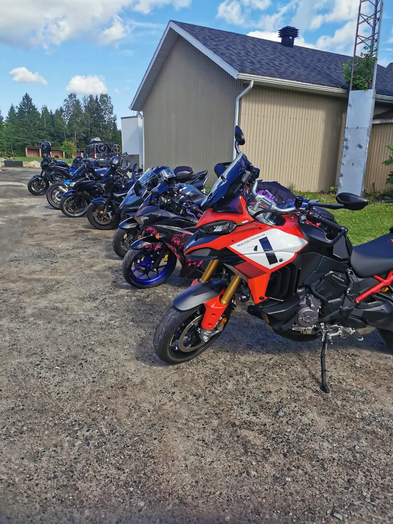 Motos du groupe alignées, avec une Ducati rouge au premier plan